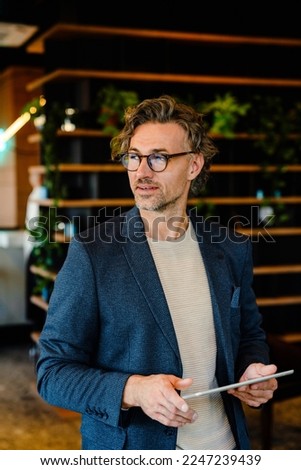 Mature manager using tablet computer during offline meeting in office