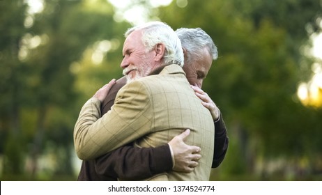 Mature men hugging, happy to see each other, old friends meeting, greeting