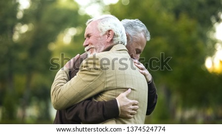 Mature men hugging, happy to see each other, old friends meeting, greeting