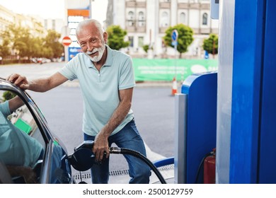 Mature men pouring fuel in vehicle at the gas station. Senior businessman standing on gas station and fueling car. - Powered by Shutterstock