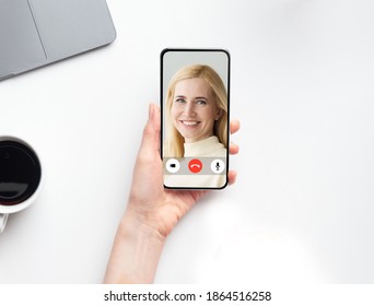 Mature Mother Calling Adult Daughter Via Video Call On Smartphone. Young Woman Holding Phone Communicating With Mom Online Sitting Indoors. Modern Distance Communication Concept. Cropped