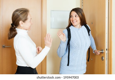 Mature mother says goodbye to daughter at the door in home - Powered by Shutterstock