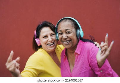 Mature Multiethnic Female Friends Enjoy Music Playlist With Wireless Technology