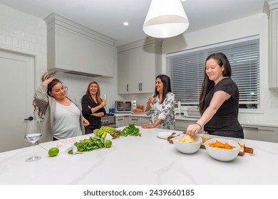 Mature Multi-ethnic friends talking and preparing food at social gathering at home in a luxury kitchen - Powered by Shutterstock