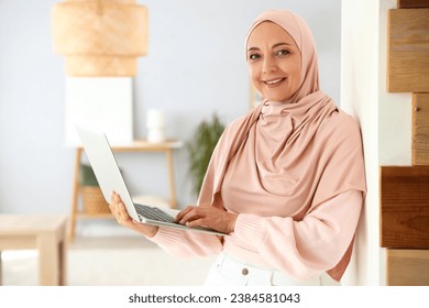 Mature Muslim woman using laptop at home - Powered by Shutterstock