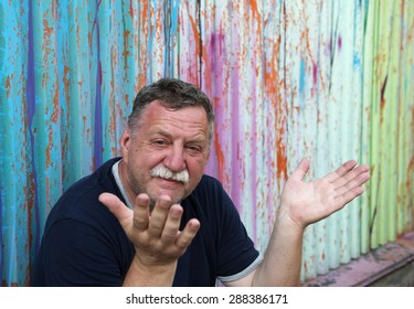 Mature Mustachioed Man Sitting Against The Wall. 