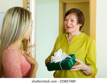  Mature Neighbor Presenting Gift To Young Girl In Door