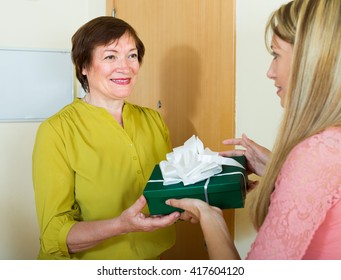  Mature Neighbor Presenting Gift To Young Girl In Door Of Home