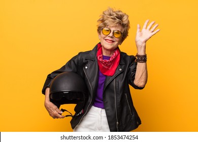 Mature Old Beautiful Woman Smiling Happily And Cheerfully, Waving Hand, Welcoming And Greeting You, Or Saying Goodbye. Motorbike Concept