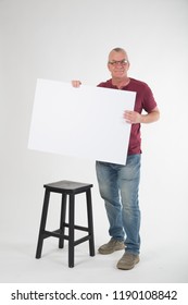 Mature Old Male Holding And Showing A Large Blank White Card With Nothing On It. Text And Copy Space. Casual Dress. Sign Or Notice Template