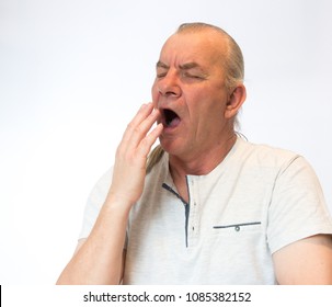 Mature Old Man Yawning, Tired And Bored, In Studio On White Background