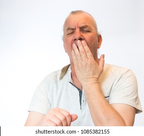 Mature Old Man Yawning, Tired And Bored, In Studio On White Background