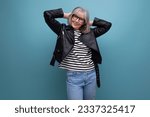 mature old woman in a stylish rocker jacket on a bright background