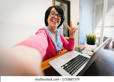 Mature Older Woman Taking A Selfie At Home Using Computer Technology.