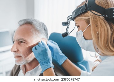 Mature patient with hearing problem visiting doctor otolaryngologist. Deafness, hear loss problems issues treatment prevention. Barotrauma otitis - Powered by Shutterstock