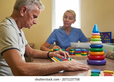 Mature Patient Using Physiotherapy Equipment For Brain Exercise In Clinic