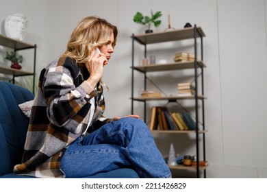 Mature Pensive Woman Talking On Phone While Sitting On Couch Indoor