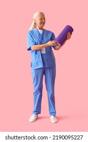 Mature Physiotherapist With Foam Roller On Pink Background