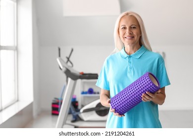 Mature Physiotherapist With Foam Roller In Rehabilitation Center