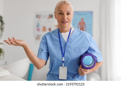 Mature Physiotherapist With Foam Roller In Rehabilitation Center