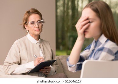 Mature Probation Officer Taking Notes While Talking With Despair Teenage Girl