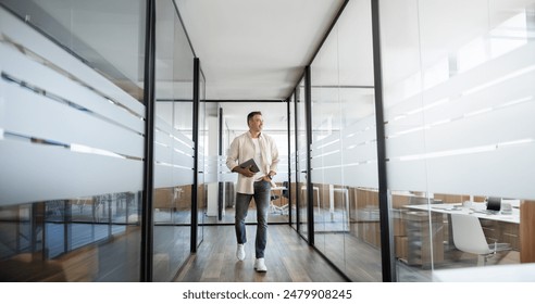 Mature professional executive business man walking, holding, using laptop pc or tablet at modern company office workplace space. Full body portrait of confident smiling senior businessman, copy space - Powered by Shutterstock