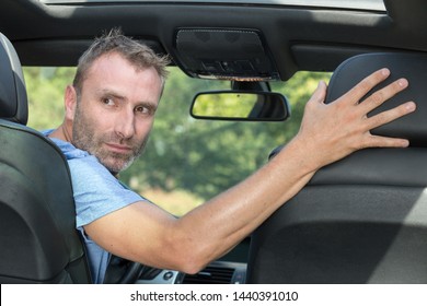 Mature Professional Man Driving A Car In Reverse