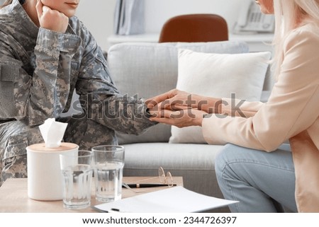 Mature psychologist working with female soldier in office