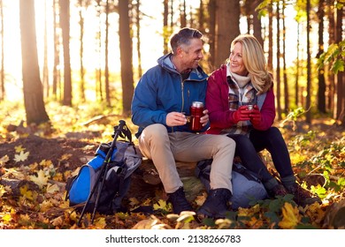 Mature Retired Couple Stop For Rest And Hot Drink On Walk Through Fall Or Winter Countryside