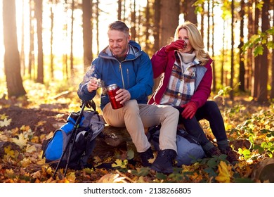 Mature Retired Couple Stop For Rest And Hot Drink On Walk Through Fall Or Winter Countryside - Powered by Shutterstock