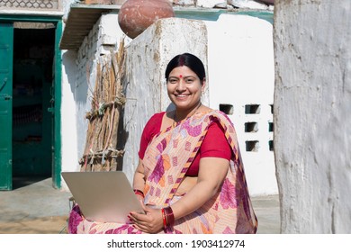 Mature Rural Woman using laptop at village.