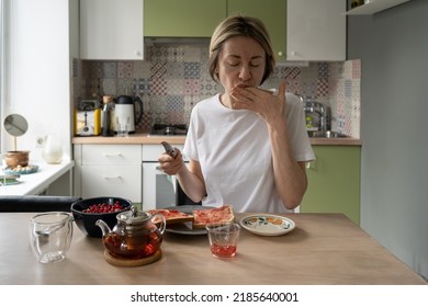 Mature Scandinavian Woman Enjoys Taste Of Jam Licking Fingers. Unwashed And Shabby Middle-aged Female Has Late Breakfast And Eats Jam Leftovers From Fingers. Unemployed Lady Does Morning Routine