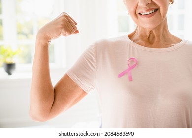 Mature senior elderly strong woman in pink t-shirt with pink ribbon supporting fighting for breast cancer movement. Togetherness, oncology recovery concept