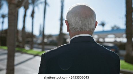 Mature senior man casually standing with his back towards the camera, revealing a backwards view on a bustling urban street, a portrait that conveys the silent wisdom of an elder beneath grey hair. - Powered by Shutterstock