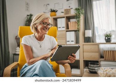 Mature senior woman sit at home and use mobile phone for text message, video call or browse internet - Powered by Shutterstock