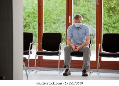 Mature Serious Patient Or Visitor Alone Sitting In An Empty Waiting Room Of An Office Or Hospital