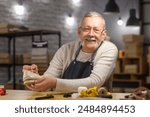 Mature shoemaker repairing shoe at table in workshop