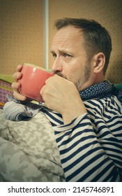 Mature Sick Man Drinking Hot Tea From Cup Alone At Home In Bed