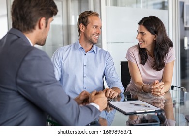 Mature Smiling Couple Meeting Financial Advisor For Investment At Office. Financial Consultant Presents Bank Investments To Man And Happy Woman. Middle Aged Couple Consulting Their Bank Agent. Saving