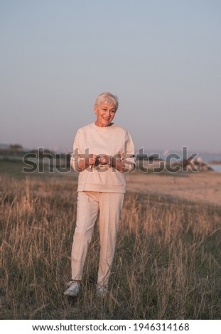 Mature smiling woman walking on the beach