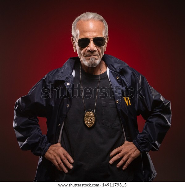 Mature Special Agent Wearing Sunglasses And A Badge With His Hands On His Hips