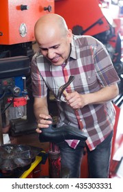 Mature Specialist Fixing Heel Taps Of Shoes On Machine