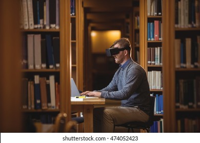 Mature student in virtual reality headset using laptop to help with studying at college library - Powered by Shutterstock