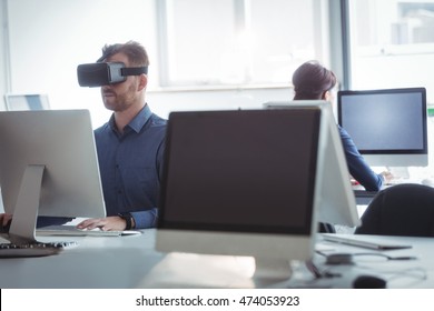 Mature student in virtual reality headset using computer to help with studying at college - Powered by Shutterstock