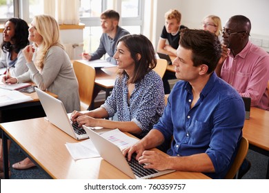 Mature Students Sitting At Desks In Adult Education Class