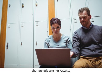 Mature students using laptop in the locker room at college - Powered by Shutterstock