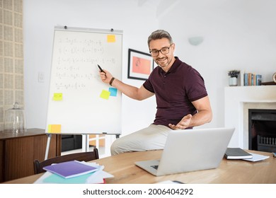 Mature teacher having online class through video call and explaining maths. Teacher teaching students maths on video call at home: e-learning via interactive platform. Mature math professor teaching. - Powered by Shutterstock