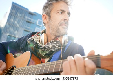 Mature Trendy Guy Playing The Guitar In The Street