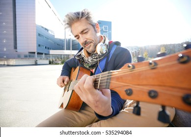 Mature Trendy Guy Playing The Guitar In The Street