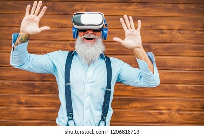 Mature trendy man having fun with virtual reality goggles technology - Senior fashion guy wearing vr headset - Tech, modern lifestyle and joyful elderly lifestyle concept - Focus on face - Powered by Shutterstock